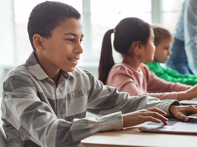 cheerful-schoolboy-using-laptop-640x480